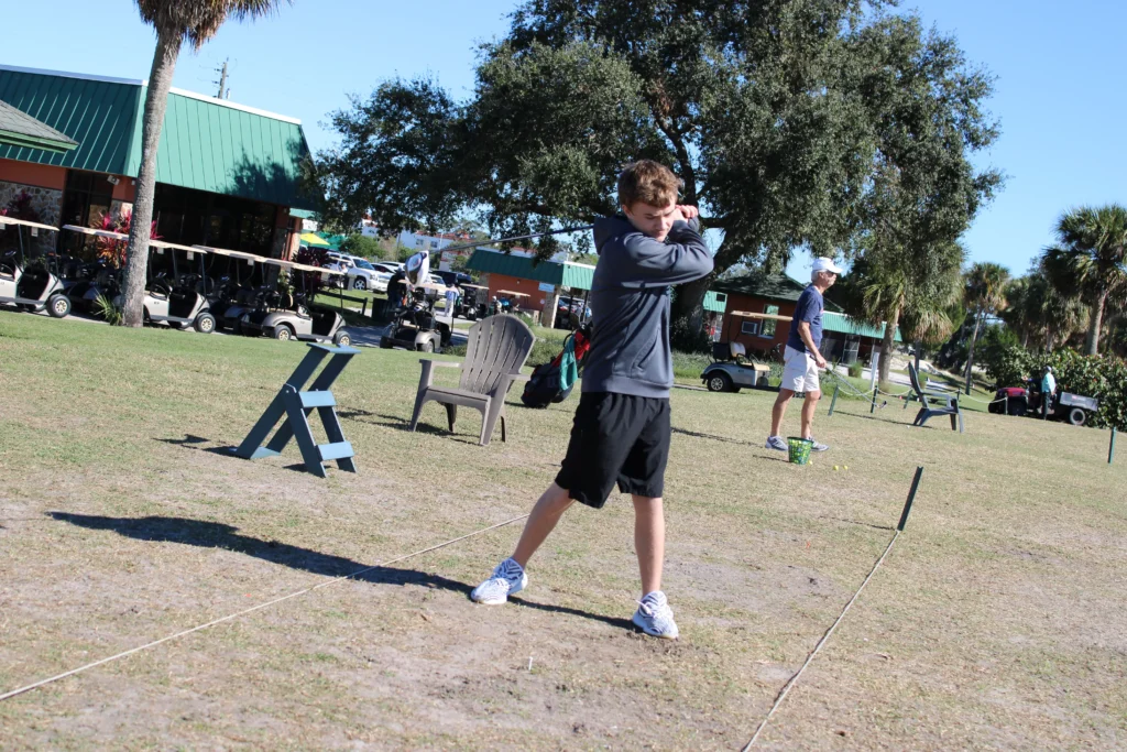 a boy swinging a golf ball